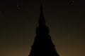 Long exposure shot of silhouette of pagoda buddhism against golden night sky with copy space stars background. Royalty Free Stock Photo