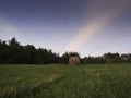 Long exposure shot of single round haystack in the meadow during summer blue hour at evening, cattle fodder in countryside Royalty Free Stock Photo