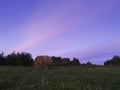 Long exposure shot of single round haystack in the meadow during summer blue hour at evening, cattle fodder in countryside Royalty Free Stock Photo