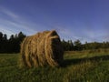 Long exposure shot of single round haystack in the meadow during summer evening, cattle fodder in countryside Royalty Free Stock Photo