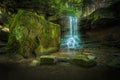 Long exposure shot of a small waterfall on the mossy rocks Royalty Free Stock Photo