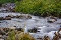 Long exposure shot of smooth water surface of Ukrainian Carpathian mountains river flowing among stones and greenery Royalty Free Stock Photo