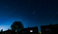 Long exposure shot of suburban night sky showing light trails of the stars for 30 minutes Royalty Free Stock Photo