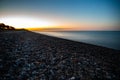 Sun going down over a pebbles beach in Denmark Royalty Free Stock Photo