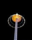 Long exposure shot of a swirling fairground carousel against a black sky