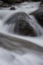 Long Exposure of Snow Melt Over Boulder Royalty Free Stock Photo