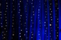 Long exposure of string fairy lights on blue illuminated curtain