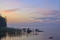 Long Exposure of Sunset at the Ladoga lake. Beautiful scape with stone beach, reeds and water. Ladoga lake, Karelia, Russia