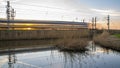 Long exposure train with setting sun shining through the train on Dutch traintrack. Royalty Free Stock Photo