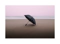 Long exposure of umbrella on the beach during sunset on a rainy day Pink pastel light colors Royalty Free Stock Photo