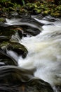 Long exposure vertical shot of a creek flowing through rocks in Sooke, Vancouver Island, BC Canada