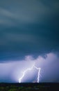 Long exposure vertical shot of dramatic clouds in the sky and lightning illuminating the area