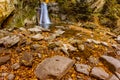 Long exposure view of the beautiful Pruncea CaÃÅ¸oca Waterfall with fallen leaves in an autumn landscape