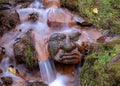 A long exposure view of water spilling over rapids, stone heads submerged in rapid river Royalty Free Stock Photo
