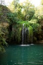 Long exposure waterfall during the day. green forest and rocky mountain. summer time. crystal clear blue water Royalty Free Stock Photo