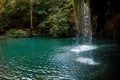 Long exposure waterfall during the day. green forest and rocky mountain. summer time. crystal clear blue water Royalty Free Stock Photo