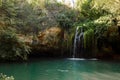 Long exposure waterfall during the day. green forest and rocky mountain. summer time. crystal clear blue water Royalty Free Stock Photo