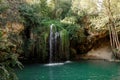 Long exposure waterfall during the day. green forest and rocky mountain. summer time. crystal clear blue water Royalty Free Stock Photo