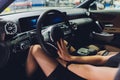 Long female legs on a steering wheel of a car. Royalty Free Stock Photo