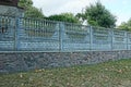 Long fence of gray concrete and brown stones