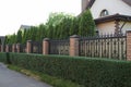 A long fence wall of brown bricks and sharp iron rods Royalty Free Stock Photo