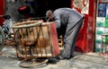 Long Feng, China: Man Repairing Bicycle Cart