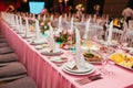 Long festive table served dishes and decorated with branches of greenery. Wedding banquet.