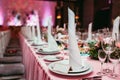 Long festive table served dishes and decorated with branches of greenery. Wedding banquet.