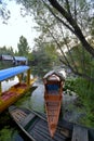 Long flat-bottomed wooden boats, shikaras, parked on a backwater canal of the Dal Lake in Srinagar, India