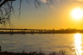 A long footpath in the park covered with yellow winter grass with bare winter trees along the banks of the Mississippi river