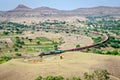 Long goods freight train passing through a big curve in hilly railway line at Daundaj, Maharashtra, India Royalty Free Stock Photo