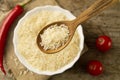 Long grain rice in a wooden spoon on a background plates, chili pepper, cherry tomato. Healthy eating, diet Royalty Free Stock Photo