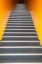 Long gray stairs with many steps and yellow wall
