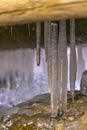 Long group of icicles forming below wooden bridge