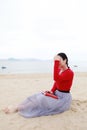 Young asian chinese woman read and Listen to the music sit on Sand Beach