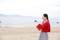 Young asian chinese woman read book walk along Sand Beach