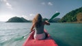 Long haired blonde woman with sunglasses rows bright pink canoe along sea bay water to beach with growing palms. Royalty Free Stock Photo