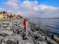 Long-haired blonde young woman takes pictures on the phone of the Bosporus seascape in Istanbul Turkey - a view from the back.