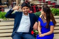 Long haired brunette indian woman in blue dress with her handsome boyfriend having dating getting bored .man giving rose Royalty Free Stock Photo