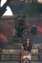 Fashionable female caucasian tourist with incense in Chinese temple in front of statute Royalty Free Stock Photo