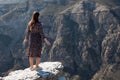 Long haired brunette stands on dangerous rocky cliff edge