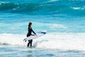 Long Haired Brunette Woman Entering The Atlantic Ocean To Surf Waves On Las Americas Beach. April 11, 2019. Santa Cruz De Tenerife