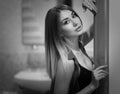 Long-haired divinely beautiful girl in lingerie posing looking at the camera near the bathroom Royalty Free Stock Photo