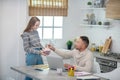 Long-haired girl in grey shirt giving marshmallows to her father