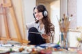 Long-haired girl in headphones paints on canvas Royalty Free Stock Photo