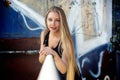 Long-haired girl near graffiti wall