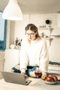 Long-haired girl in stylish rugged jeans working on her laptop