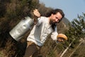 Long-haired grower offering a milk churn and bread Royalty Free Stock Photo