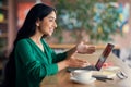 Long-haired indian lady having online job interview, cafe interior Royalty Free Stock Photo