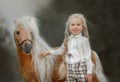 Little girl with palomino miniature horse in summer day Royalty Free Stock Photo